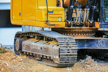 Close-up of an excavator’s steel track and rotating base on a construction site. Heavy-duty machinery designed for rugged terrain and earthmoving in industrial or urban development projects