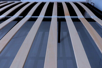 Wooden Slats on Metal Bed Frame &ndash; Detailed Structure of Modern Bed Base with Curved Plywood Supports for Mattress in Minimalist Bedroom Interior