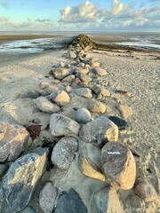 Stones arranged in a line against sunset on Foehr