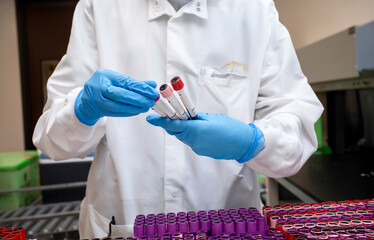 Close up of a lab worker holding test tubes