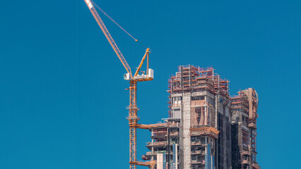 Aerial view of a skyscrapers under construction with huge cranes timelapse in Dubai.