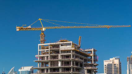 Aerial view of a skyscrapers under construction with huge cranes timelapse in Dubai.