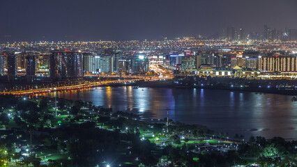 Obraz premium Night city near park and road with lights and high traffic aerial timelapse