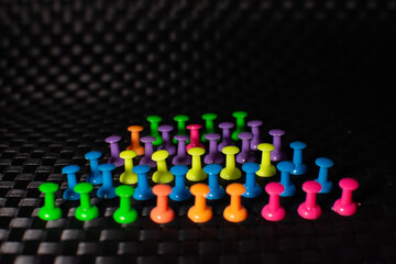 Colored pins placed on a black background.