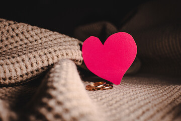Wedding rings with a paper heart simulating marital love and commitment.