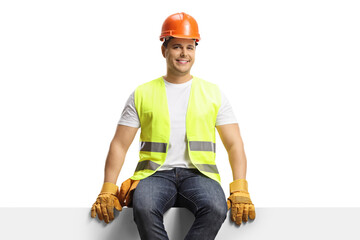 Construction worker with a helmet sitting on a panel