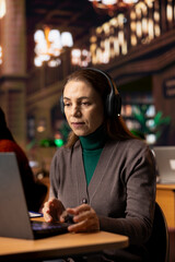 Adult scholar attends a university briefing via wireless video conference, engaged in a...