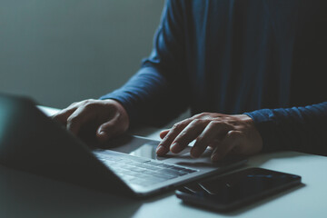 Man hand typing on laptop with smartphone. Digital work, remote business task, freelance project, online communication. Business technology, online learning, digital marketing and working from home.