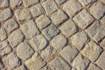 Cobblestone pavement background. Pavement road background. Bricks road. Brick surface background. Rough brick road Textured background. Sidewalk. Old cobblestone road.