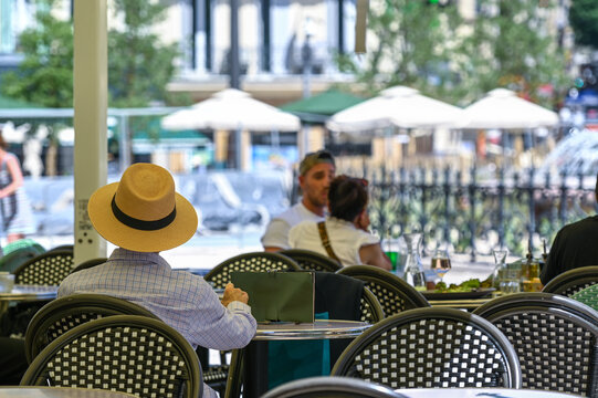 Marseille, France : Relaxed outdoor lunch in a French caf&eacute;. Man with straw hat sitting at table, summer sunlight, Mediterranean lifestyle, Castellane, Marseille, France