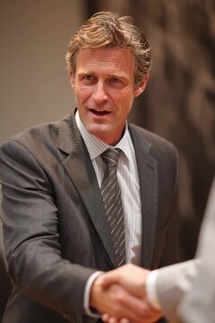 The financial advisor greets the client and shakes his hand. Portrait of a businessman during an office meeting