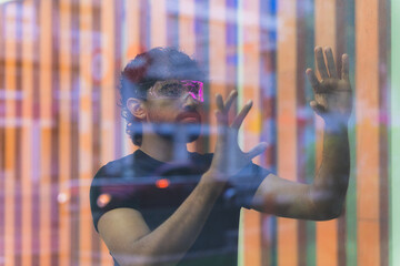Latin software developer using augmented reality headset and interacting with a holographic...