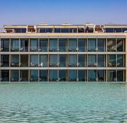 New building with open balconies and swimming pool in front of the building