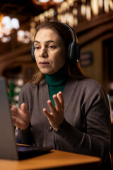 Female student joins a remote video call for an online university course, studying digital...