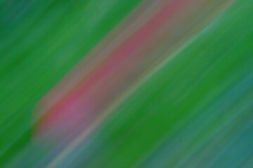Abstract motion blur image featuring vibrant green and pink hues, creating a dynamic visual effect...