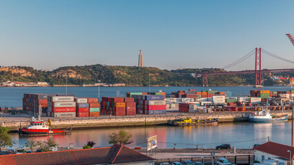 Skyline over Lisbon commercial port timelapse, 25th April Bridge, containers on pier with freight...