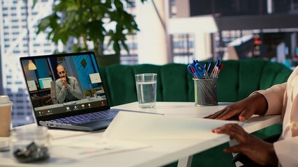 Black director pitching a new project to shareholders group on teleconference call, discussing...