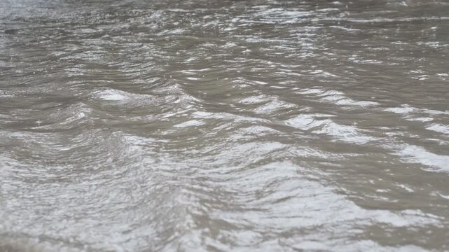 The water is murky and has a brownish tint. The waves are choppy and the water is moving quickly