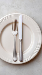 Elegant table setting with empty plate and silver cutlery for dining arrangement