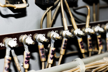 Detailed close-up of numbered electrical terminal screws with labeled wires in an industrial control panel or switchboard