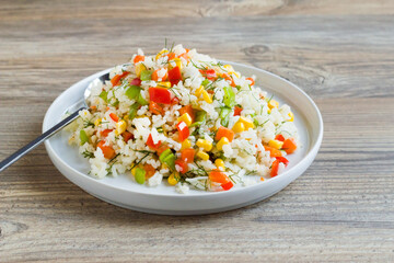 Rice salad or pilaf with colorful vegetables from Asian cuisine.,served with a spoon 