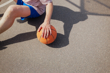 Basketball player reaching for the ball on a sunny court