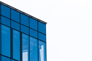 Modern glass building facade on white sky background, minimalist urban architecture