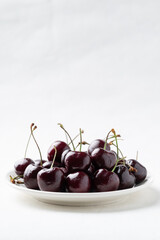 Fresh ripe cherries fruit on white plate with clean white background, Healthy eating and seasonal