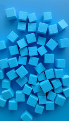 Randomly lying blue foam cubes. Graphic concept. Blue foam cut into cubes. Blue background. Volumetric image. Styrofoam, color sketch. White tone