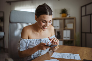 Adult woman have contactless payment scan invoice on cellphone at home