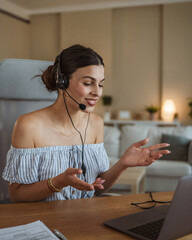 adult woman with headset have web conference while working from home