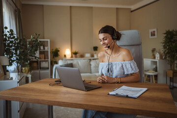 adult woman with headset have web conference while working from home