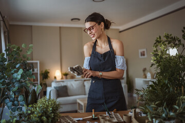 woman gardener put gloves on hands, take care grow cultivate plants