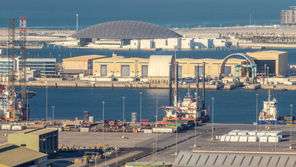 Big cargo ship at industrial port timelapse aerial fiew from above at evening in Abu Dhabi
