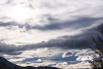 contrasty sky with dark and white clouds over tasmanian mountains in Australia