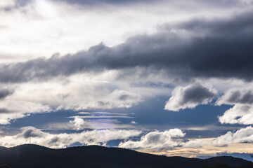 contrasty sky with dark and white clouds over tasmanian mountains in Australia