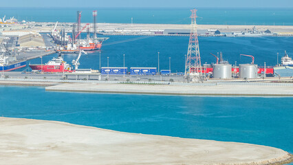 Big cargo ship at industrial port timelapse aerial view from above at evening in Abu Dhabi