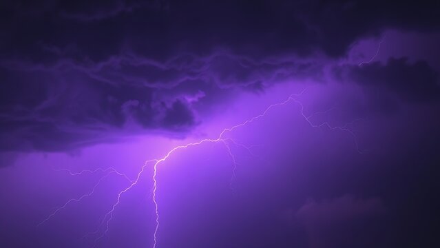 Dramatic purple lightning illuminating a stormy night sky, capturing raw natural energy.