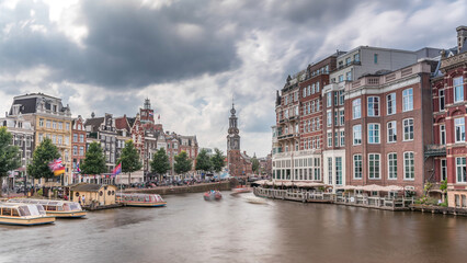 Naklejka premium Panoramic timelapse hyperlapse of Amsterdam city center featuring Amstel River, waterfront and Munttoren tower. Netherlands