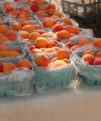 Ripe peaches in blue baskets at a market stall.