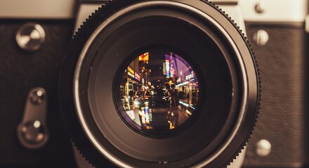 Close-up of a vintage camera lens reflecting a vibrant city street at night, concept for urban exploration photography, retro technology appreciation and nightlife themes inspiration