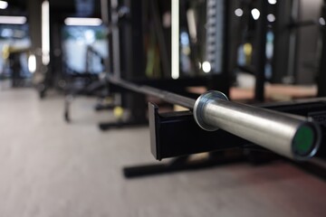 Professional barbell and other equipment in gym, closeup. Space for text