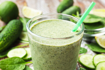 Tasty spinach smoothie and ingredients on table, closeup