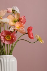 Beautiful poppy flowers in vase on pink background, closeup