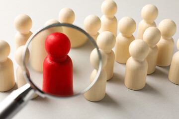 Unemployment. Human figures and magnifying glass on light background, closeup