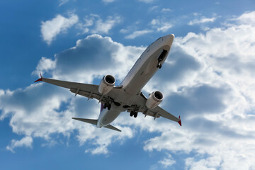 Airplane flying in beautiful blue sky with clouds