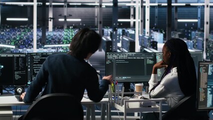 Server room system administrators using AI to review infrastructure diagnostics. IT professionals in data center analyzing performance data using artificial intelligence technology, camera A - Powered by Adobe