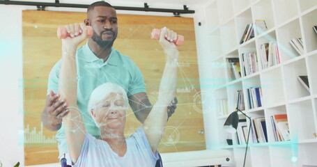Male caregiver guiding senior woman in wheelchair lifting pink dumbbells in therapy, data overlay