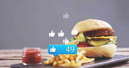 Highlighting cheeseburger on board in studio with fries and ketchup, thumbs-up bubble, copy space