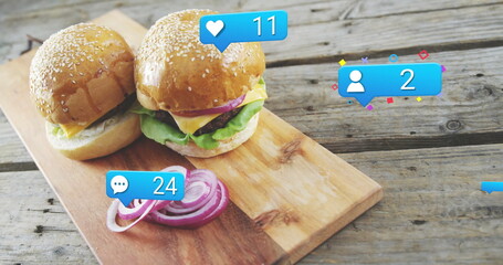 Displaying sesame seed burgers with lettuce and cheese resting on board, with social icons